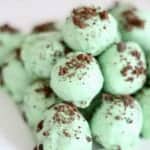 No Bake Thin Mint Cookie Truffles stacked in a pyramid on a serving plate.