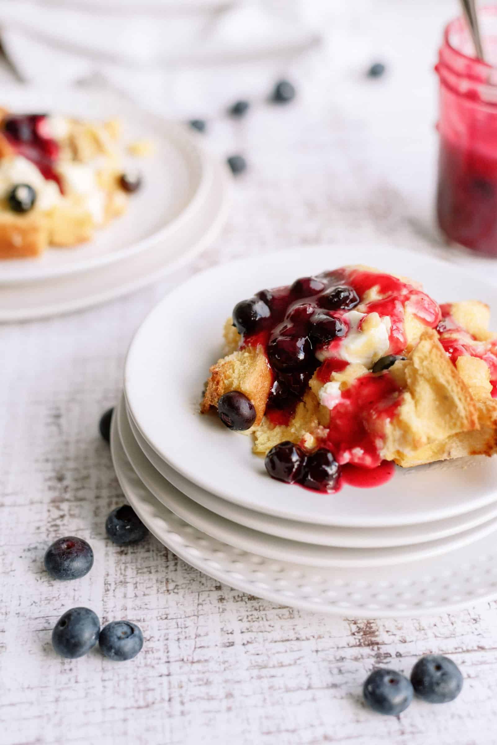 A slice of Overnight Blueberry French Toast on a plate with fresh blueberries.