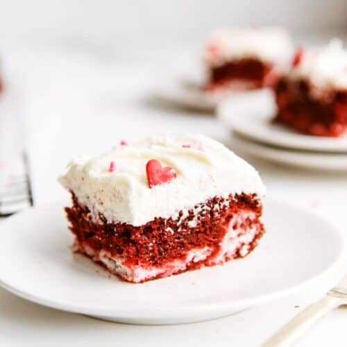 A slice of Red Velvet Cheesecake Swirl Cake on a white dish.